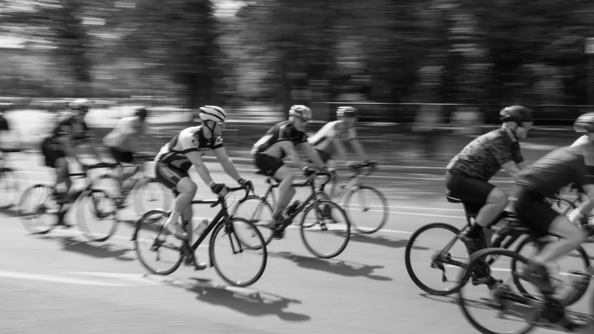 Un groupe de coureurs lancés, en noir et blanc, dans le flou de la vitesse.